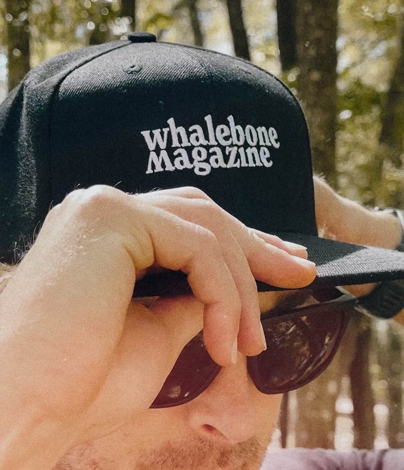 A man wears and fixes the black whalebone magazine hat he's wearing